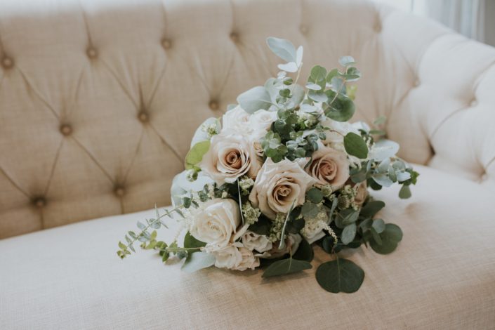 Blush and ivory bridal bouquet designed with roses, ranunculus, astrantia, astilbe and a mixed variety of eucalyptus