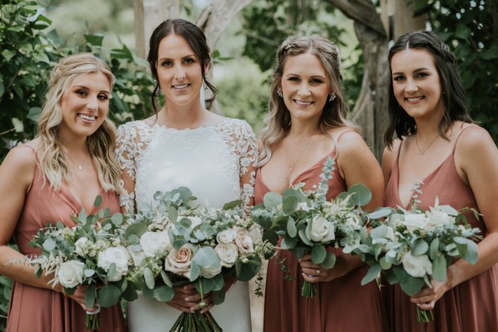 Rusty Rose Wedding; Bride and rusty rose bridesmaids with white, ivory and blush bouquets designed with roses and ranunculus