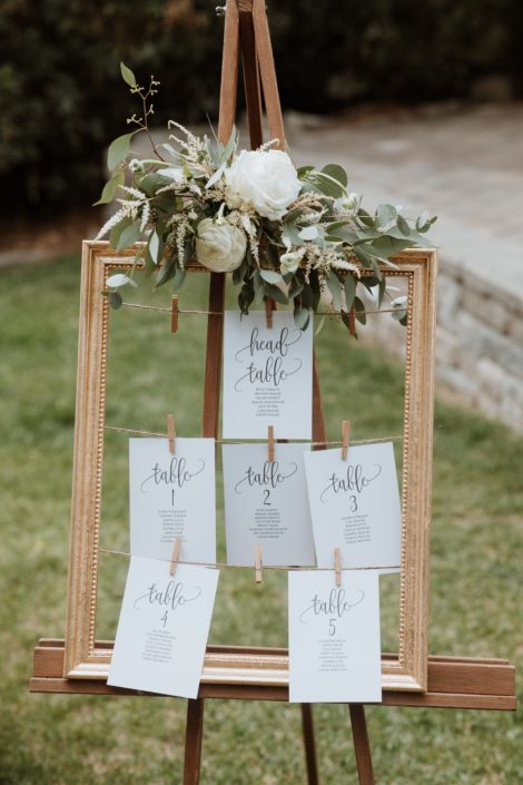 Seating sign garland made of eucalyptus greenery with a few white flowers
