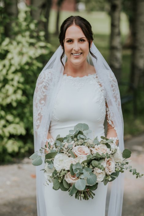 Bride, Brandi, with white, ivory and rusty rose bouquet designed of roses and ranunculus