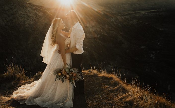 Boho Bride and groom with bouquet in Drumheller at sunset