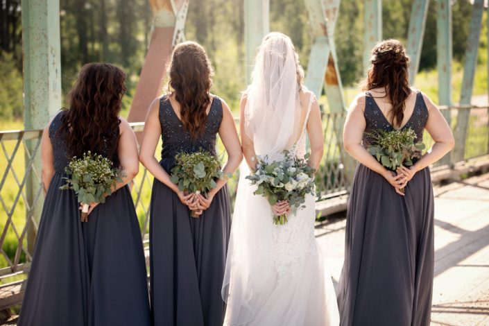 Bride and bridesmaids with bouquets behind backs