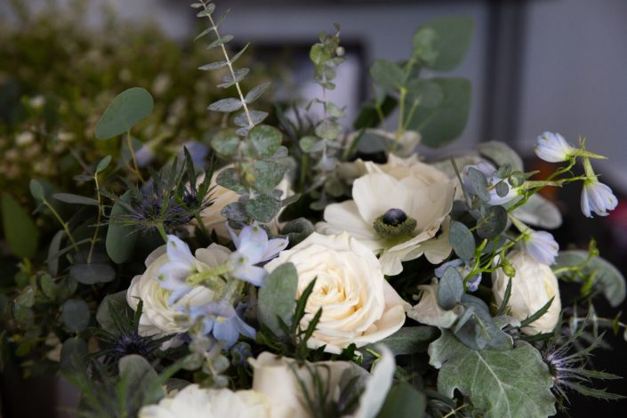 Blue and white bridal bouquet designed with panda anemone, brunia, delphinium, dusty miller, eryngium, white ranunculus, playa blanca roses and eucalyptus