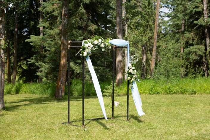 Archway arrangements designed with blue and white flowers on a pipe archway with blue drapery