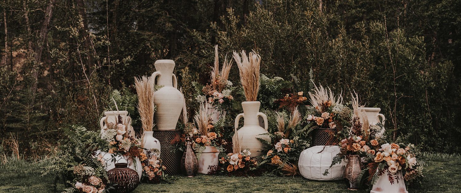 Modern Boho Ceremony set up featuring pampas grass, roses, ferns, and various types of modern boho decor and pottery