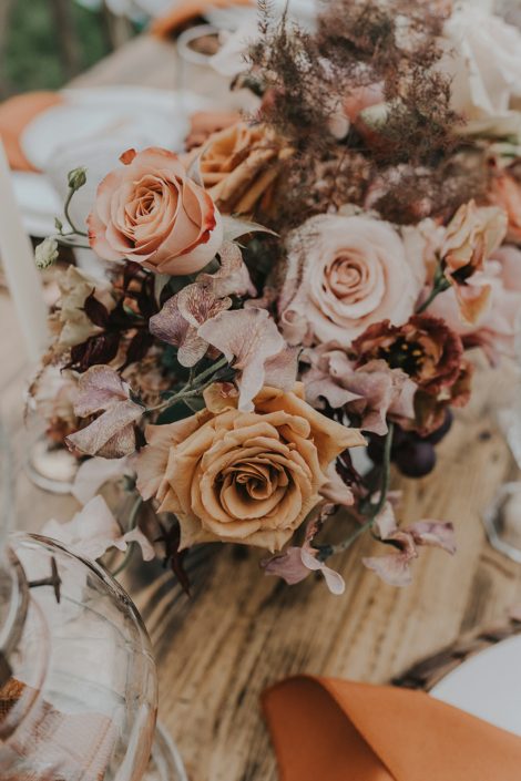 Modern boho florals in rust, terracotta and peach tones such as roses, lisianthus, and sweet peas