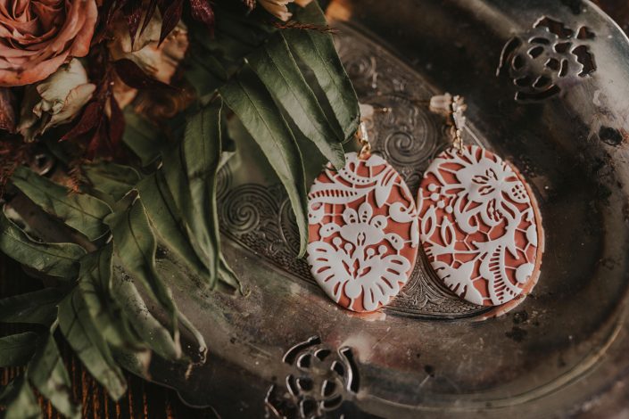 Terracotta coloured earrings with fern