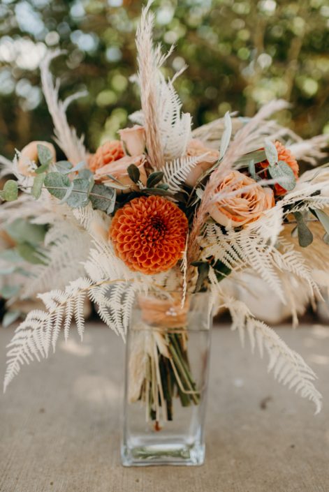 Orange Boho Bridal Bouquet designed with bleached bracken fern, bunny tail, dahlias, ranunculus, cappuccino roses, eucalyptus, olive branches and pampas grass
