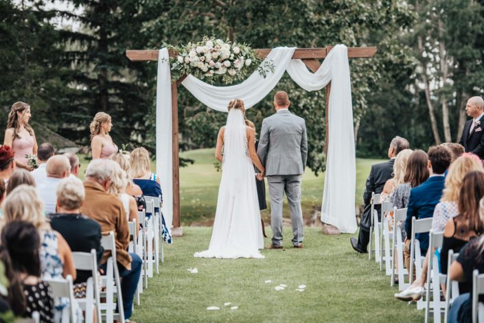 wedding ceremony with floral archway
