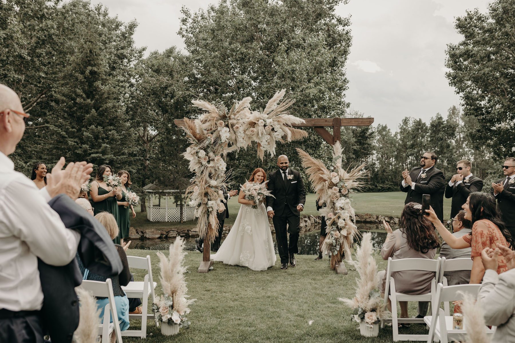 Bride and groom under a wedding floral arch