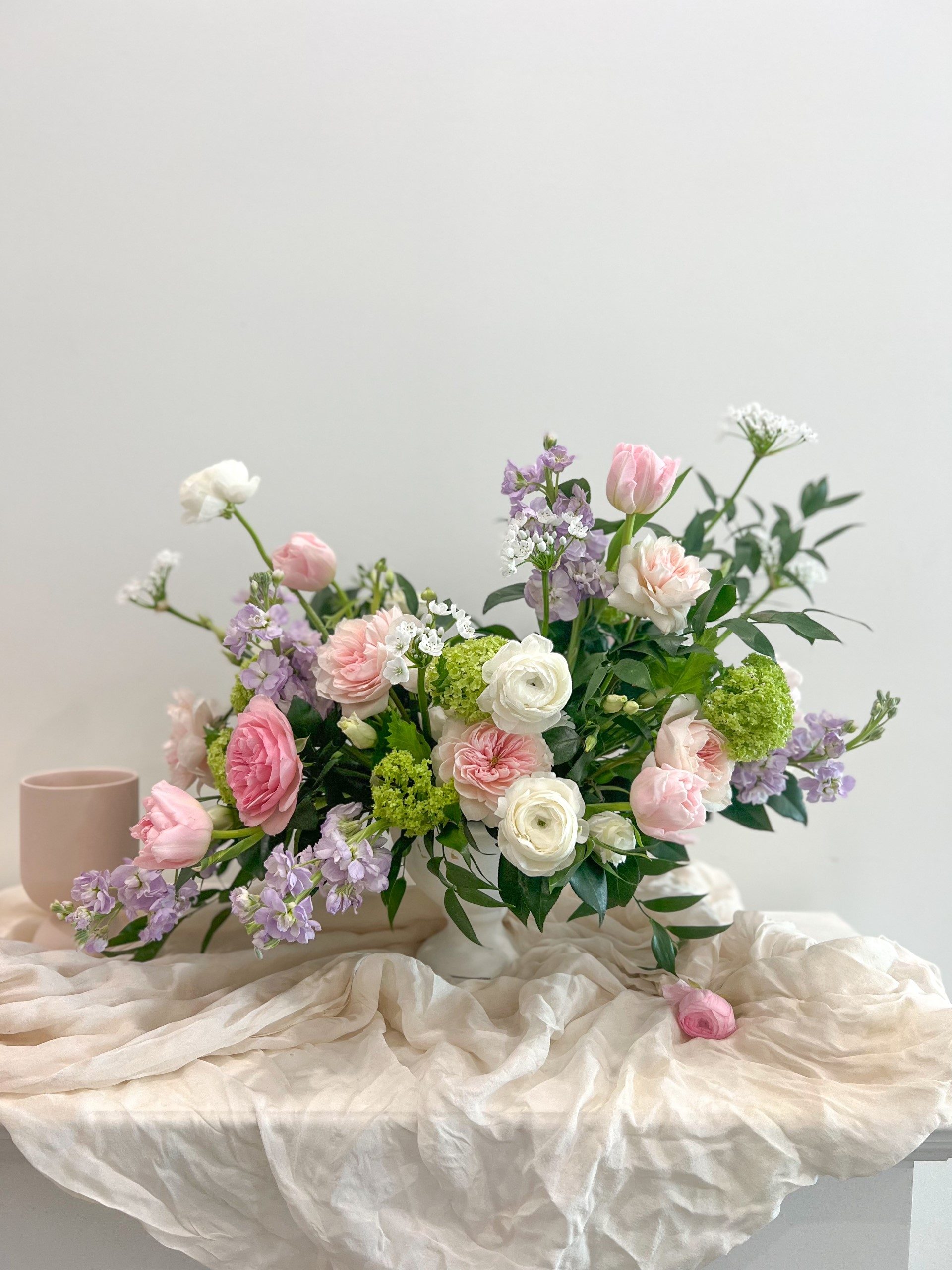 A gorgeous arrangement in an organic style full of depth and texture with fragrant blooms