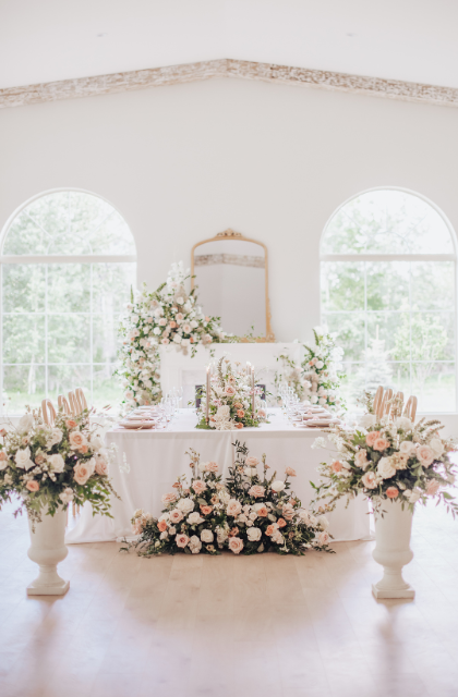 luxury wedding flowers in blush and white filling a stunning wedding venue