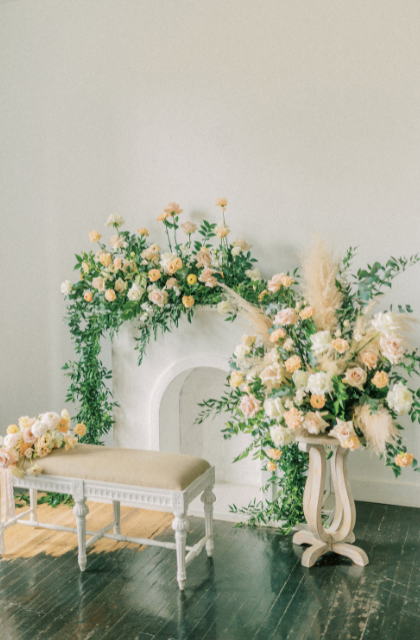 blush, white and an array of soft coloured flowers displayed over a fireplace and in vases for a funeral
