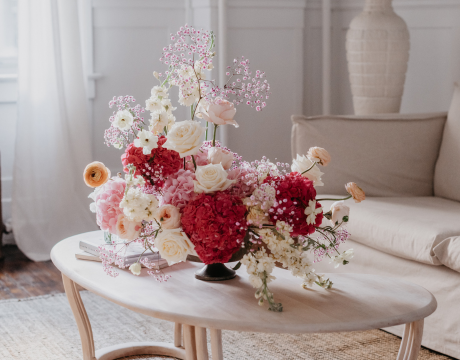 Red pink and white flower arrangement on coffee table