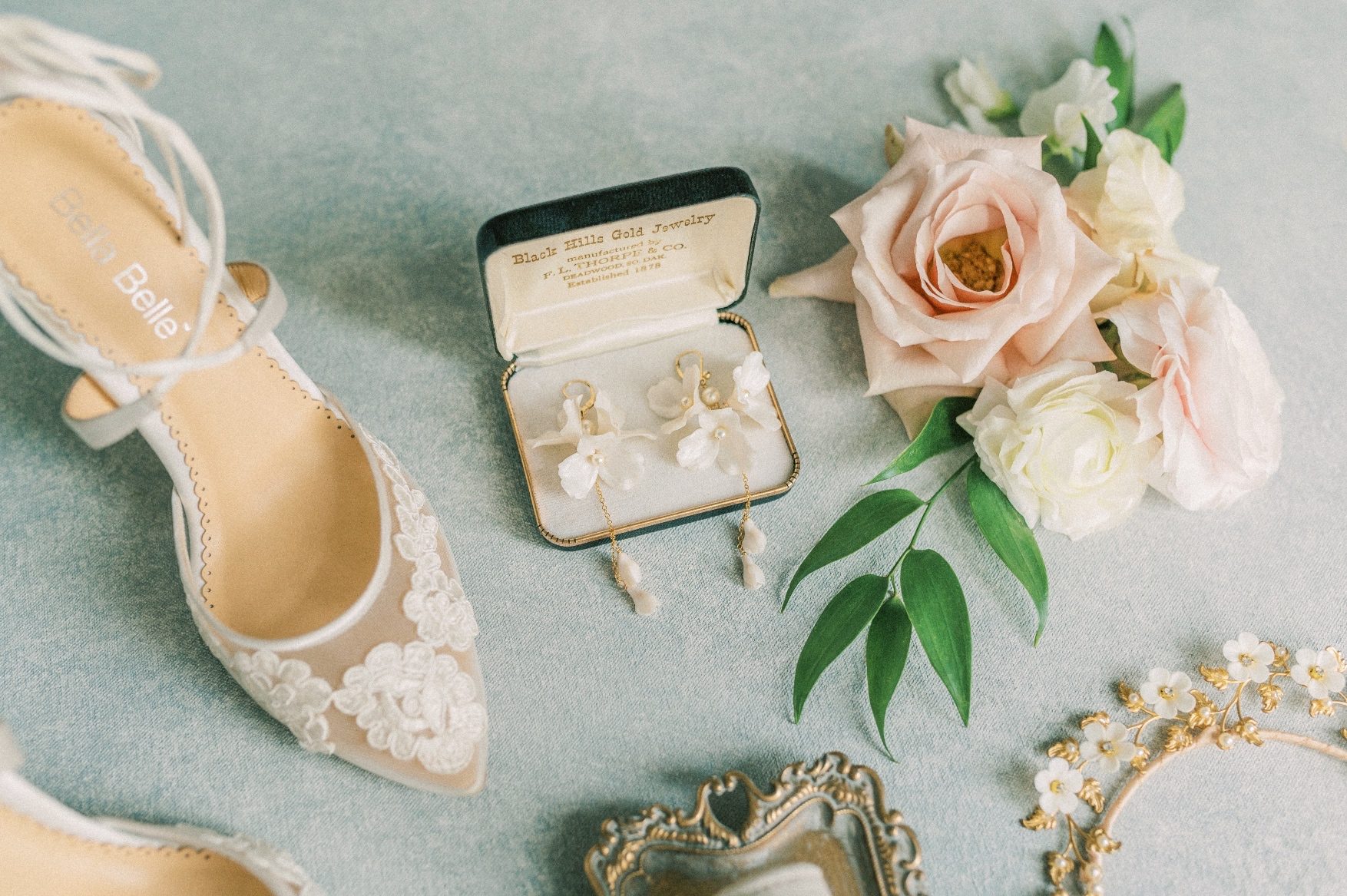 A close up of the floral earrings and shoes with a cluster of flowers