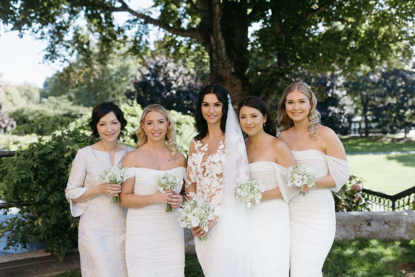 A Calyx bride with her four bridesmaids, all with delicate white posy bouquets