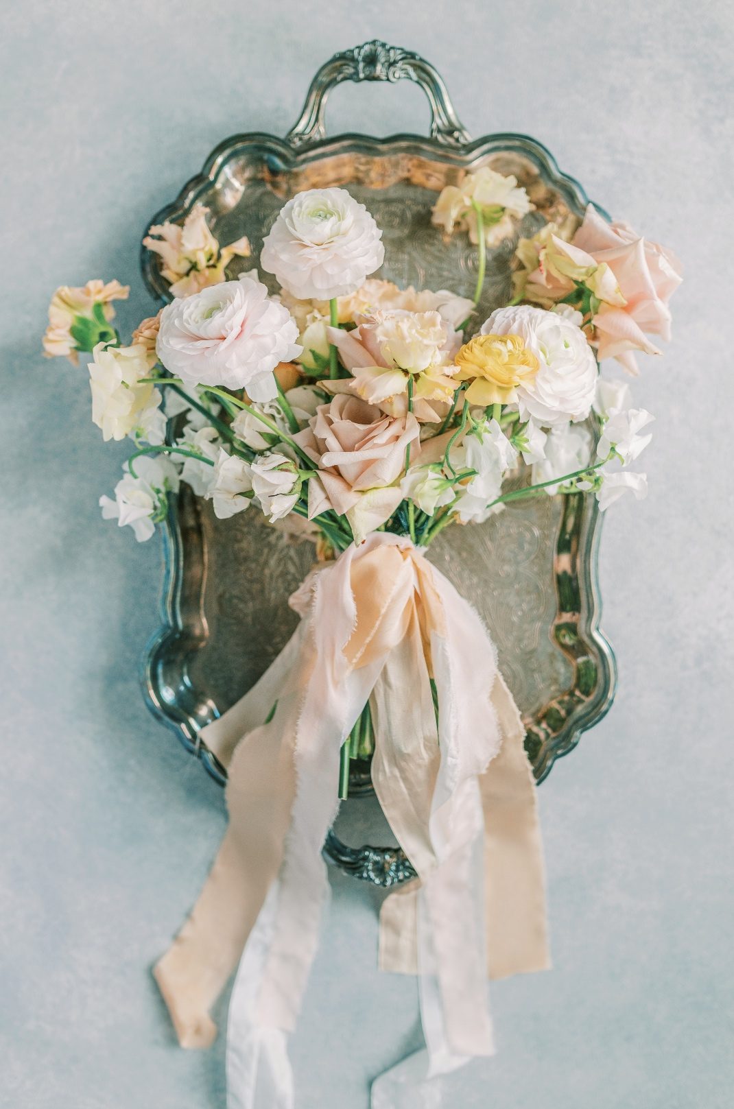 A flat lay shot of a beautiful Calyx Floral Design bouquet in an ornate silver tray