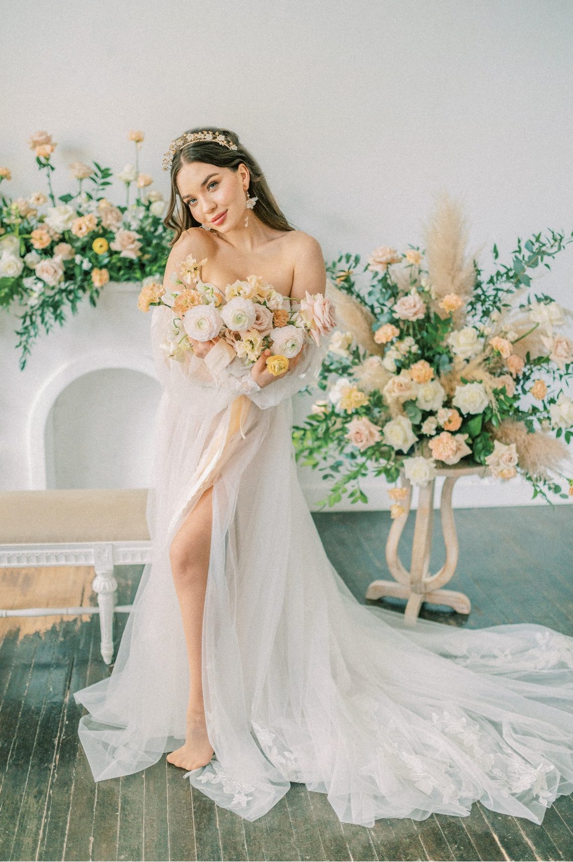 Our beautiful model holding her peach bouquet with big floral arrangements in the background