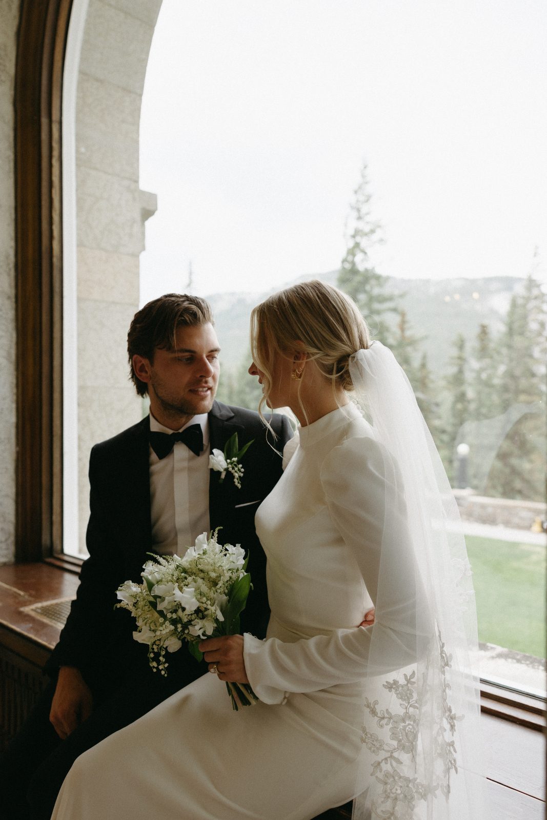 A Calyx couple sitting at a window at the Banff Fairmont