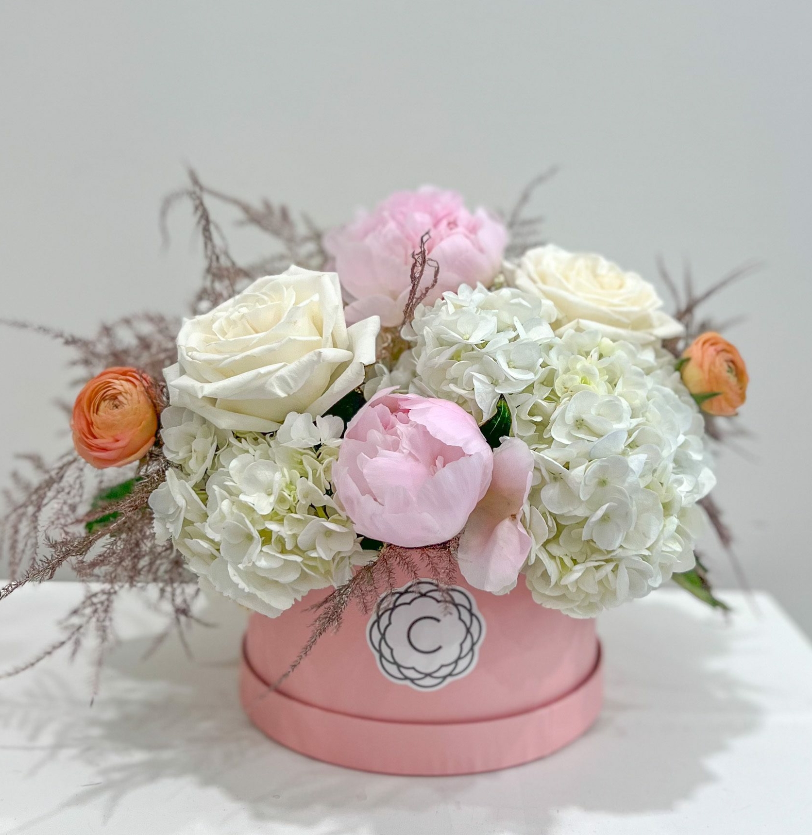 The Coco Chanel is an elegant arrangement full of white, blush and peach blooms designed into a stylish blush hat box