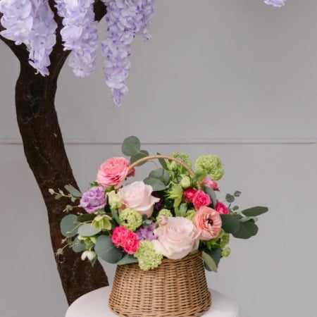 Bella's basket is a woven basket filled with a bright mix of spring flowers, a perfect arrangement for Mother's Day!
