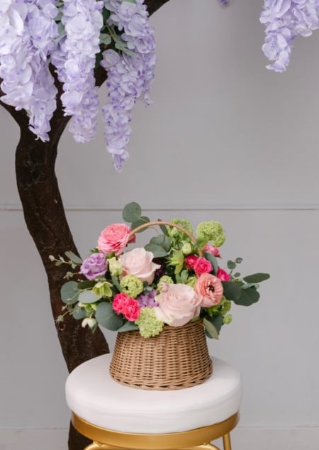 Bella's basket is a woven basket filled with a bright mix of spring flowers, a perfect arrangement for Mother's Day!