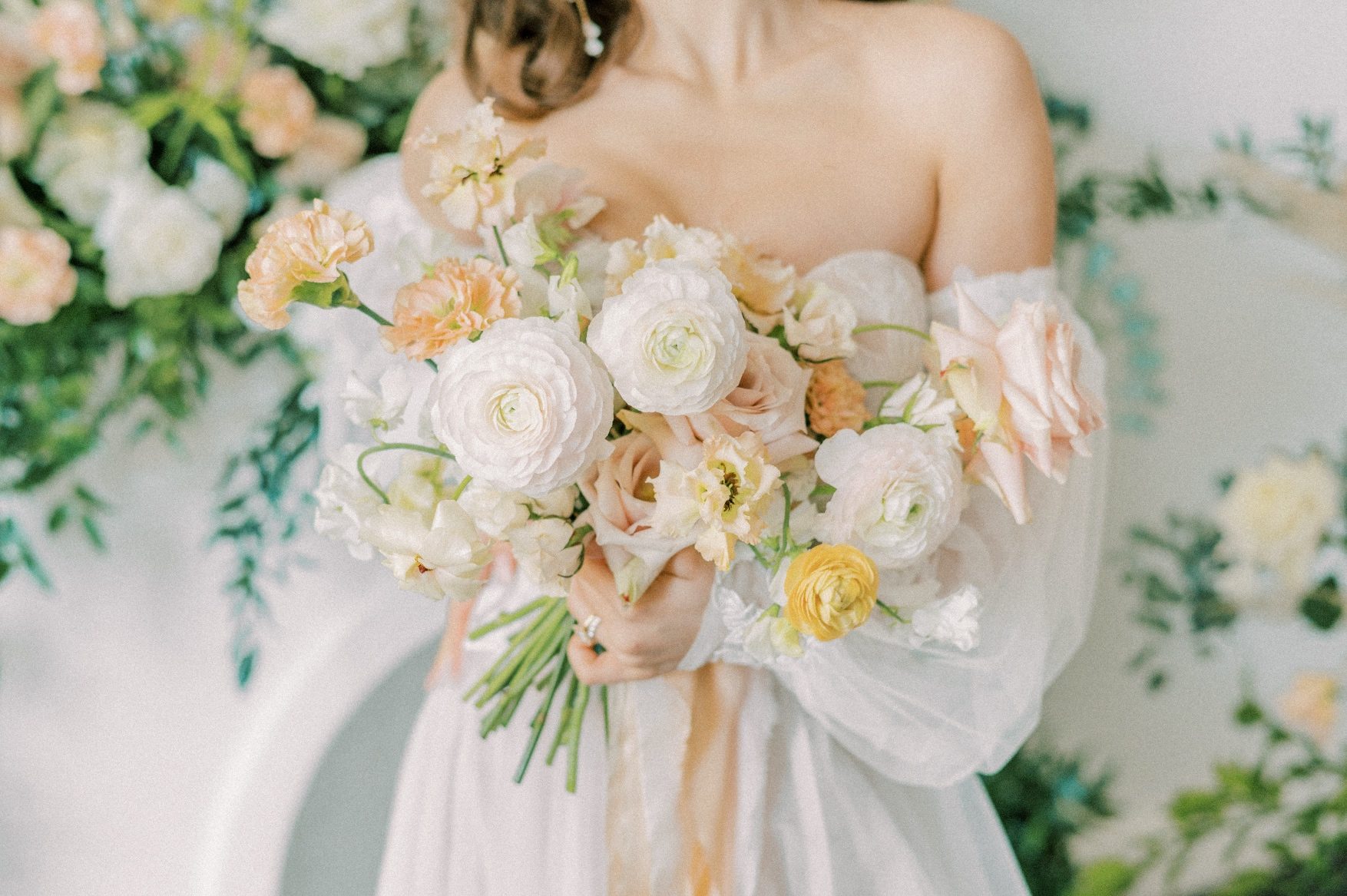 A close up of the Calyx Floral Design bridal bouquet featuring peach, blush and white blooms