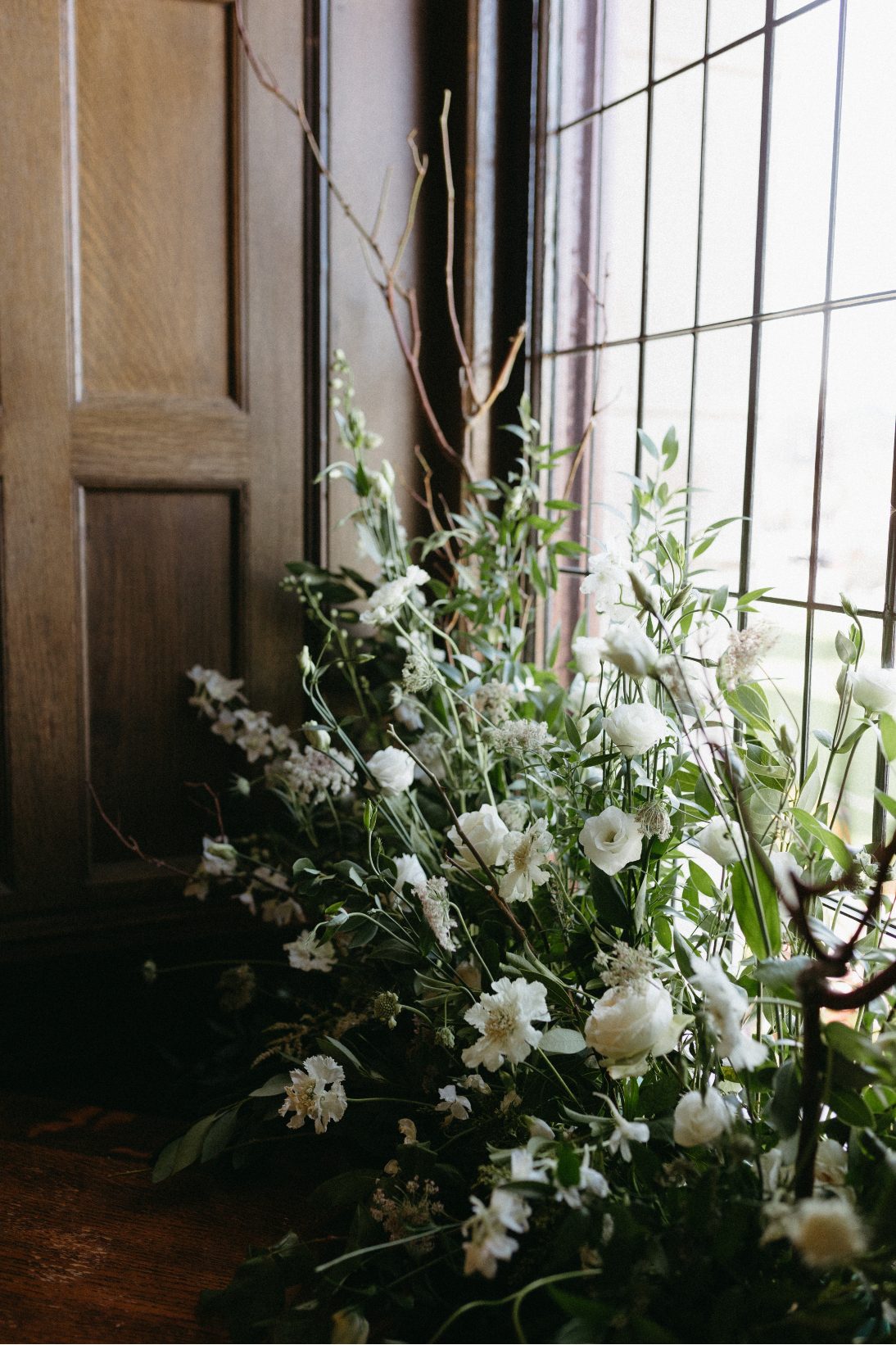 A close up of the ceremony arrangements, full of lush greens and crisp white blooms.