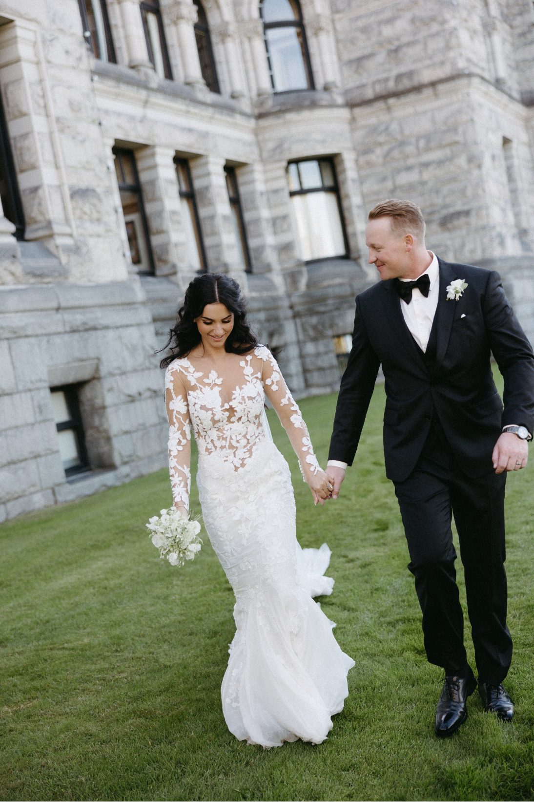 The glowing couple, walking through the grounds, holding hands and both smiling