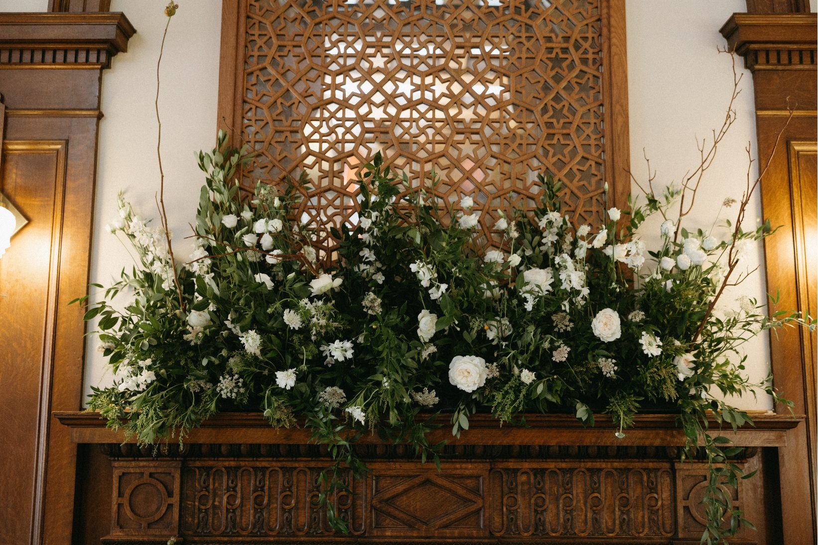 A close up of one of the beautiful natural styled arrangement at the reception, full of greenery and white flowers.