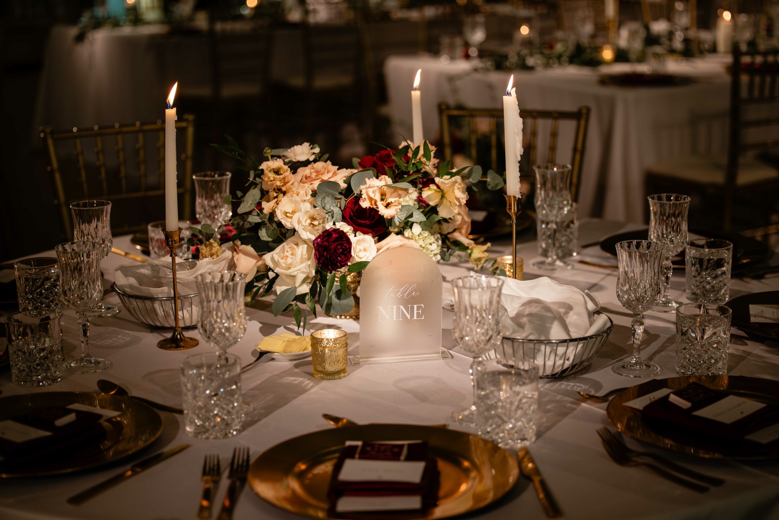 The shorter centrepieces on round tables, with beautiful blooms in burgundy, blush and ivory.