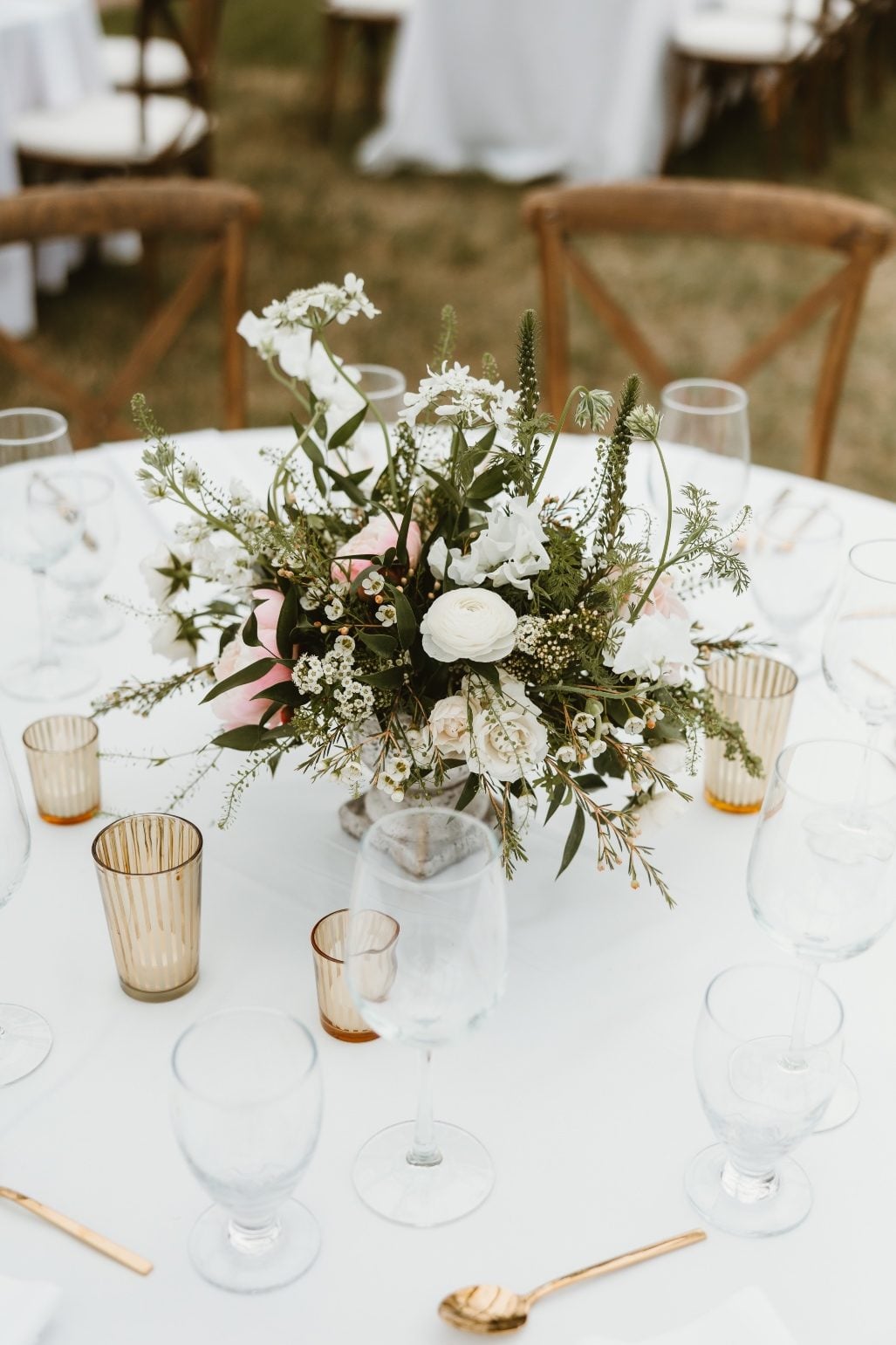 Centrepiece One of the round table centrepieces in white, green and blush designed into a stone pedestal vase