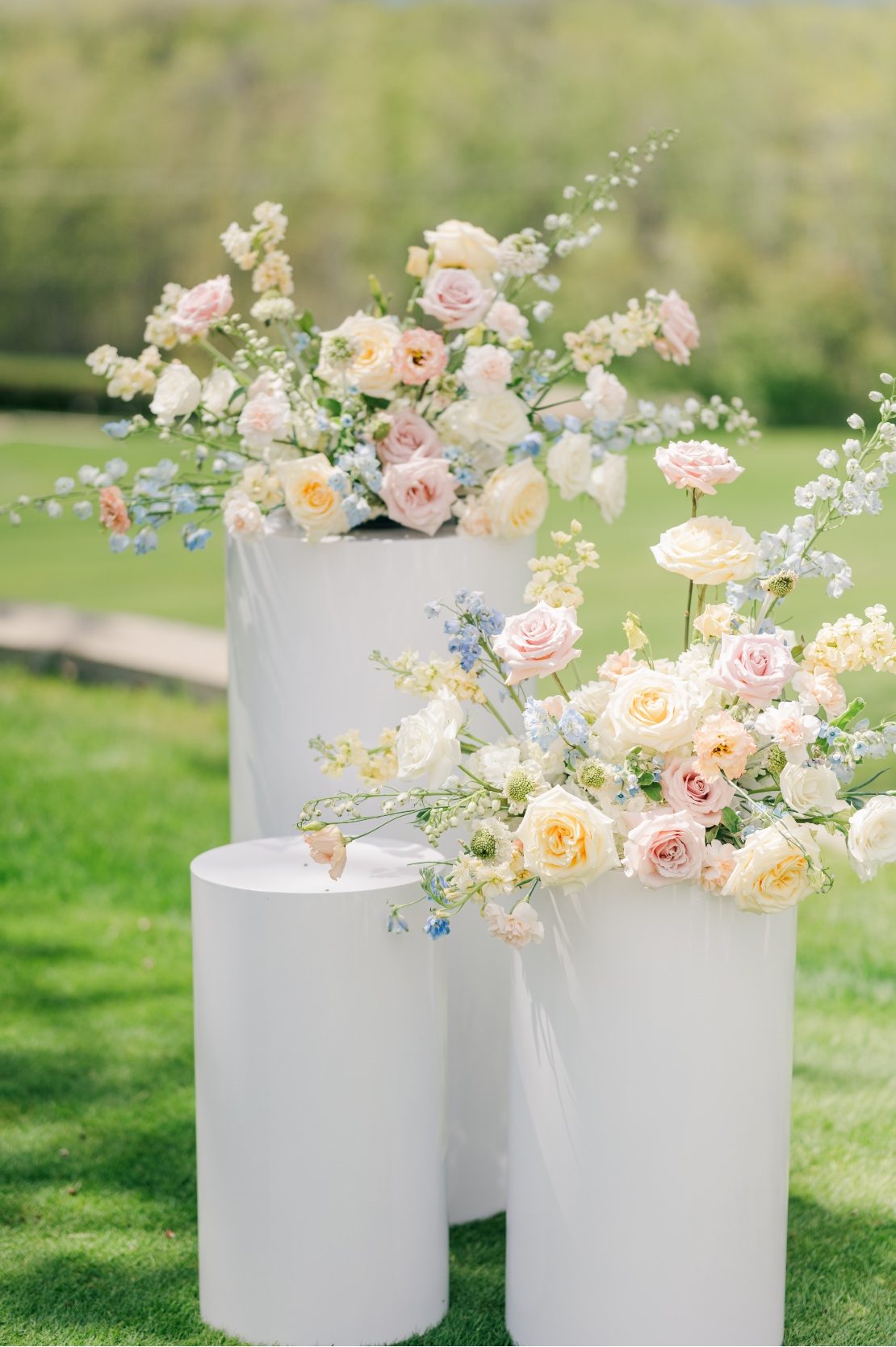 Big, pastel arrangements featuring roses, delphinium, stock, carnations, scabiosa, lisianthus and forget me nots.