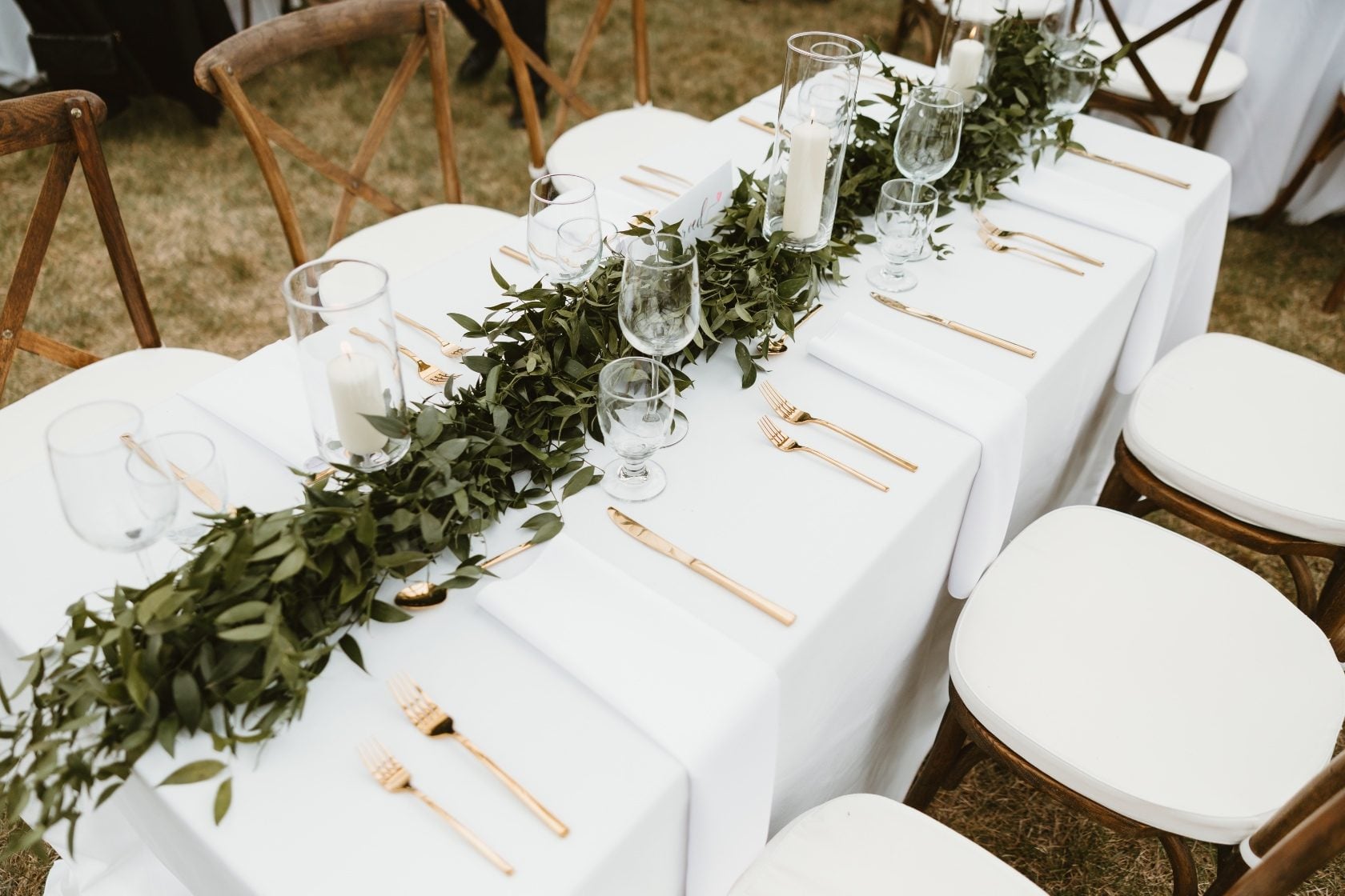 Long Table Garland Viewing one of the long rectangular tables from above, with a full, fluffy garland running down the center of the table.