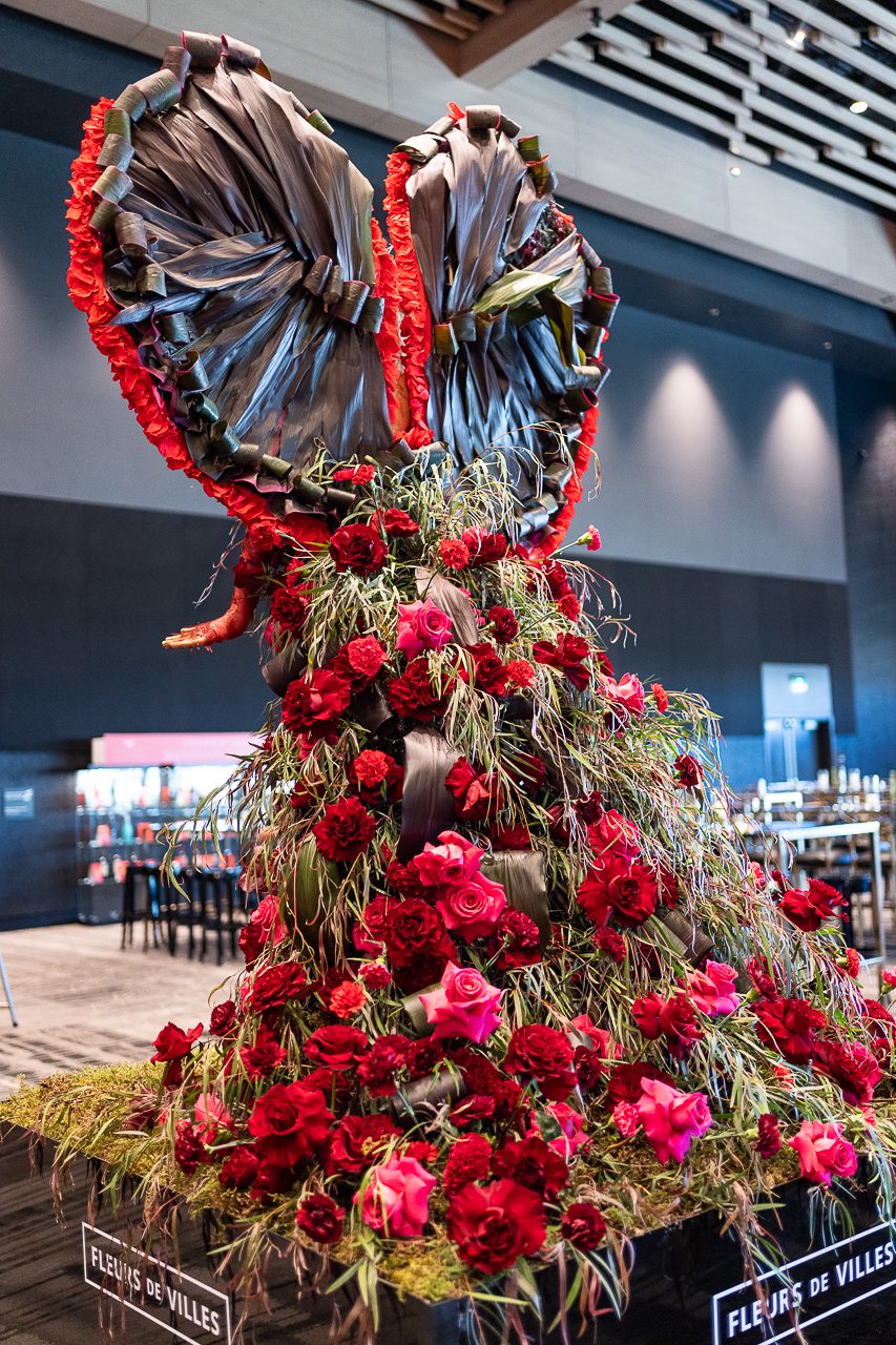 A photo of the back of the display, showing off the floral skirt of the design full of roses, carnations, orchids and celosia