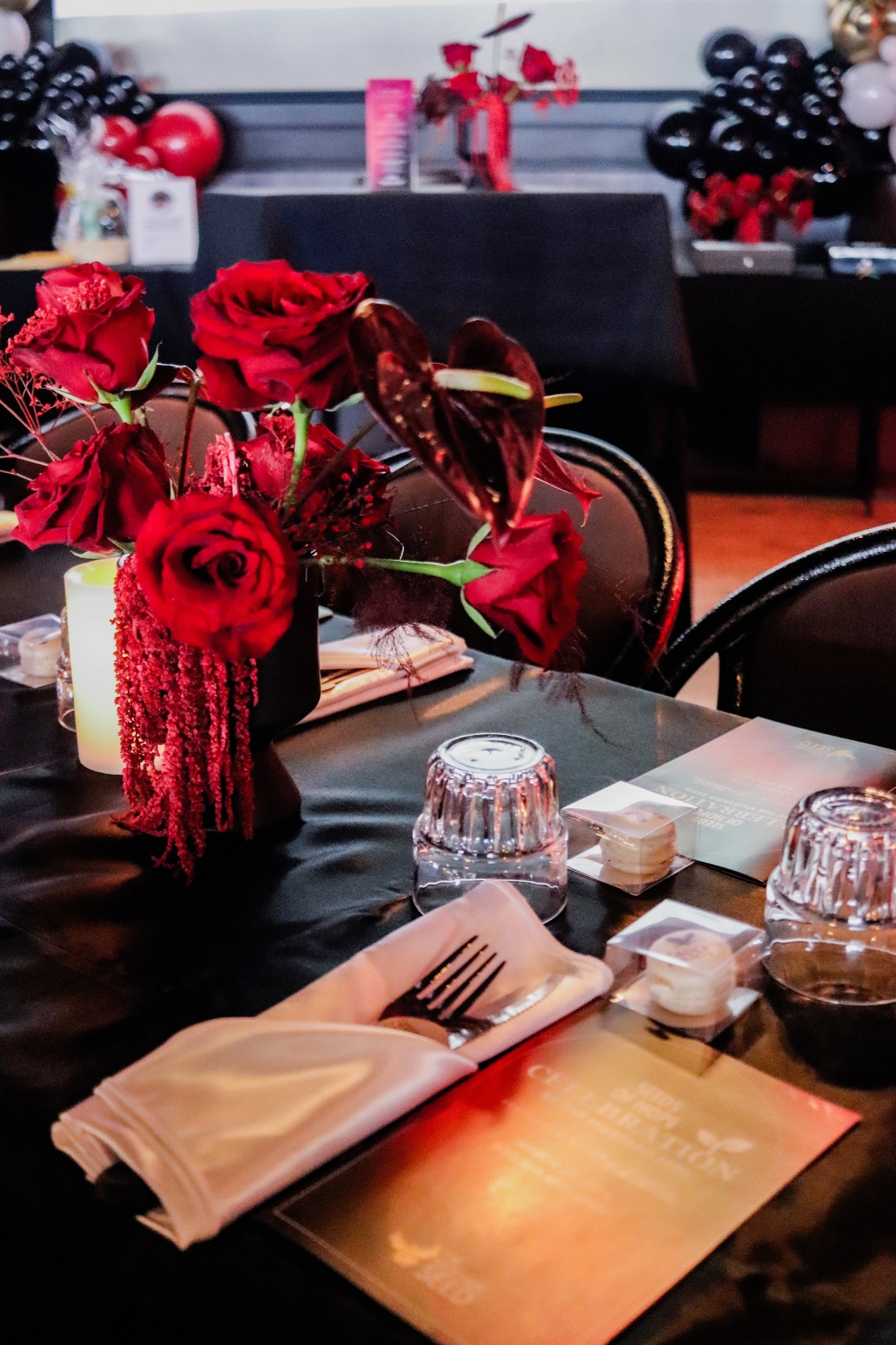 A monochromatic red centrepiece at the Mustard Seed celebration, featuring roses, anthurium, hanging amaranthus, red plumosa and red babies breath.