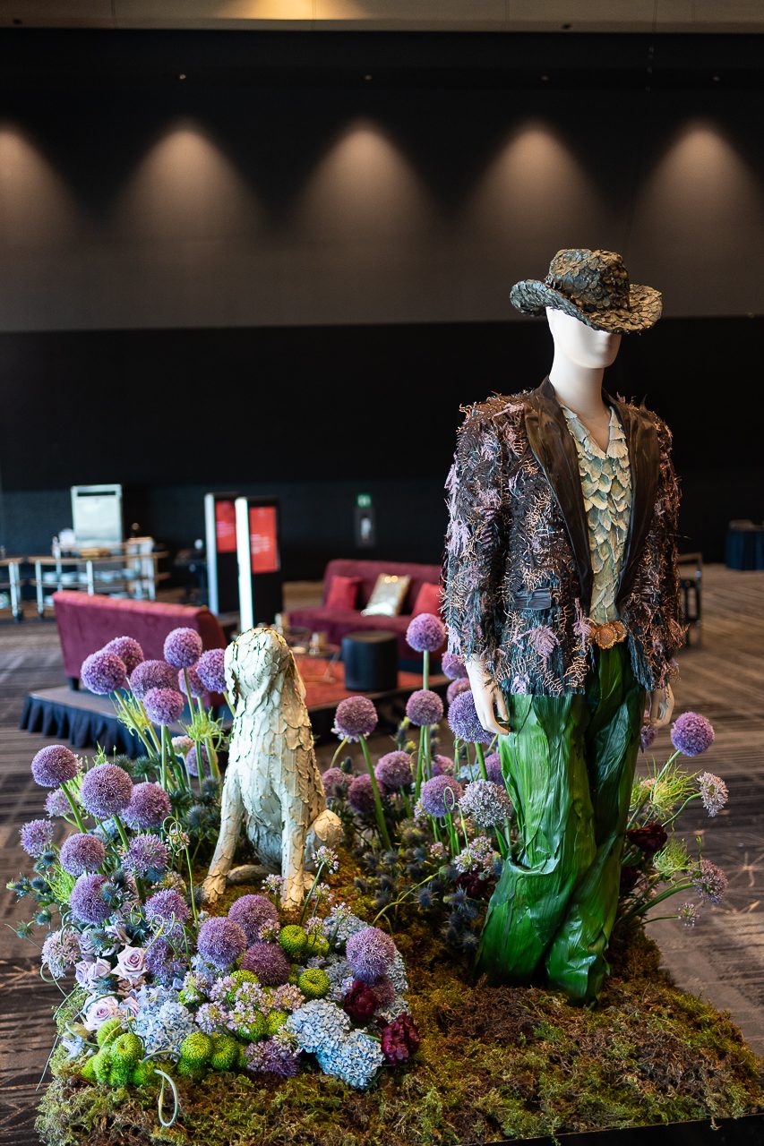 A beautifully done display for Tim McGraw with masculine toned flowers, nicely made suit (complete with a belt buckle) and his dog.