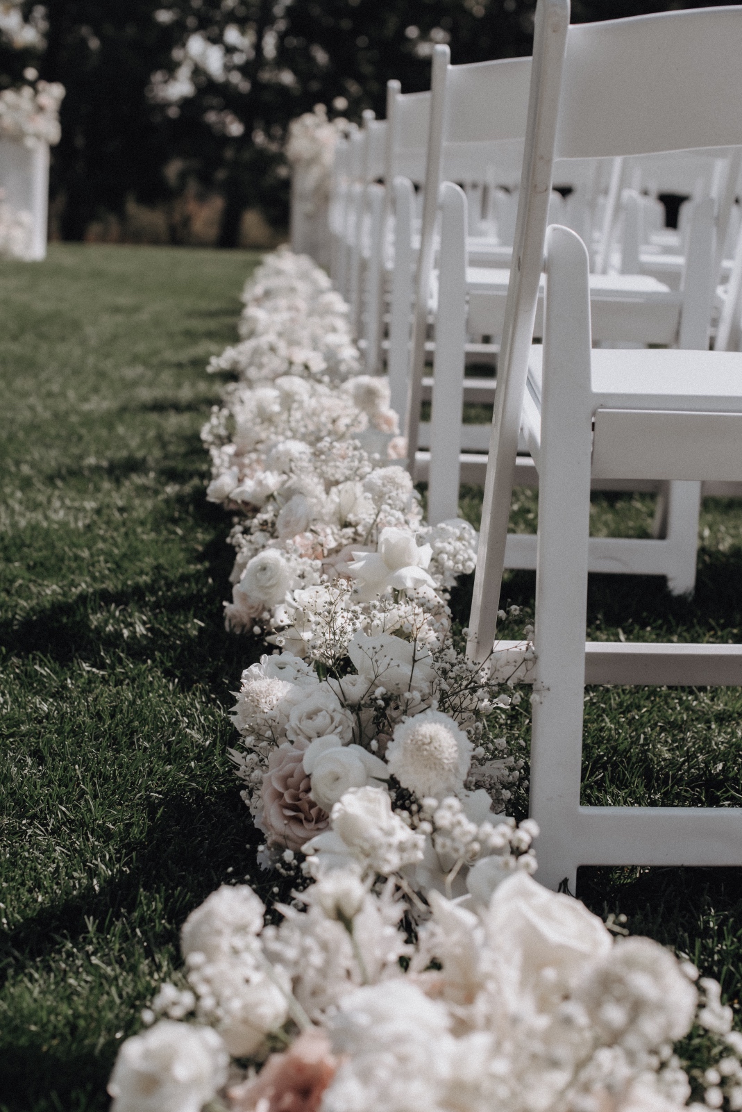 Aisle Flowers The low "floral hedge" going down the aisle made up of arangements with water picked roses tucked into the grass in between.
