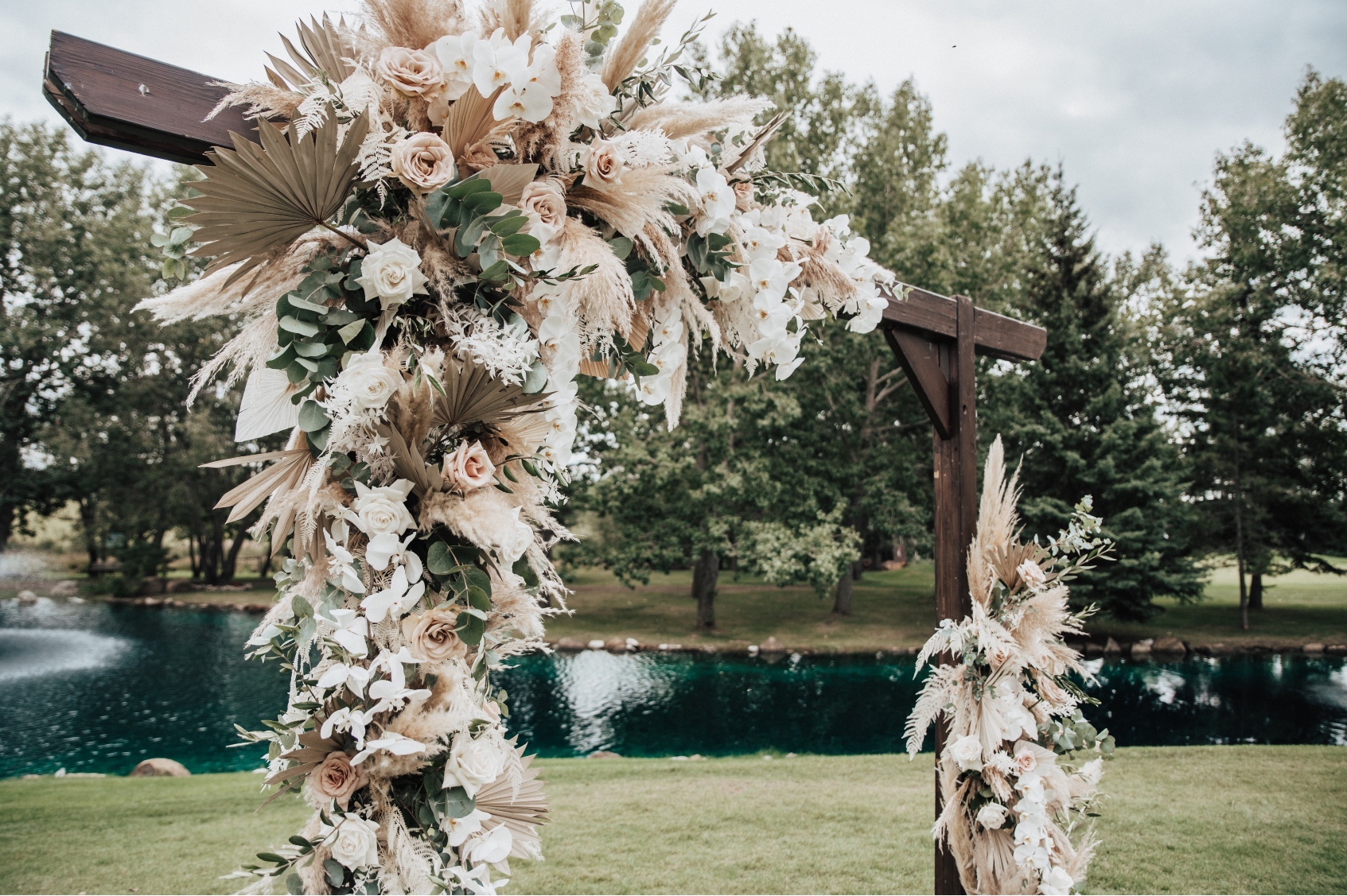 A close up shot to capture some of the details of the fabulous flowers in the archway including roses, orchids, dried palms, pampas grass, bleached ruscus, eucalyptus and olive branches.