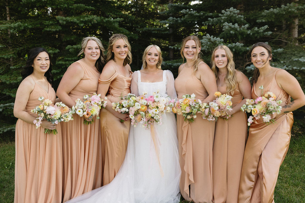 McKinley and her gorgeous bridesmaids in elegant peach gowns and pastel bouquets.