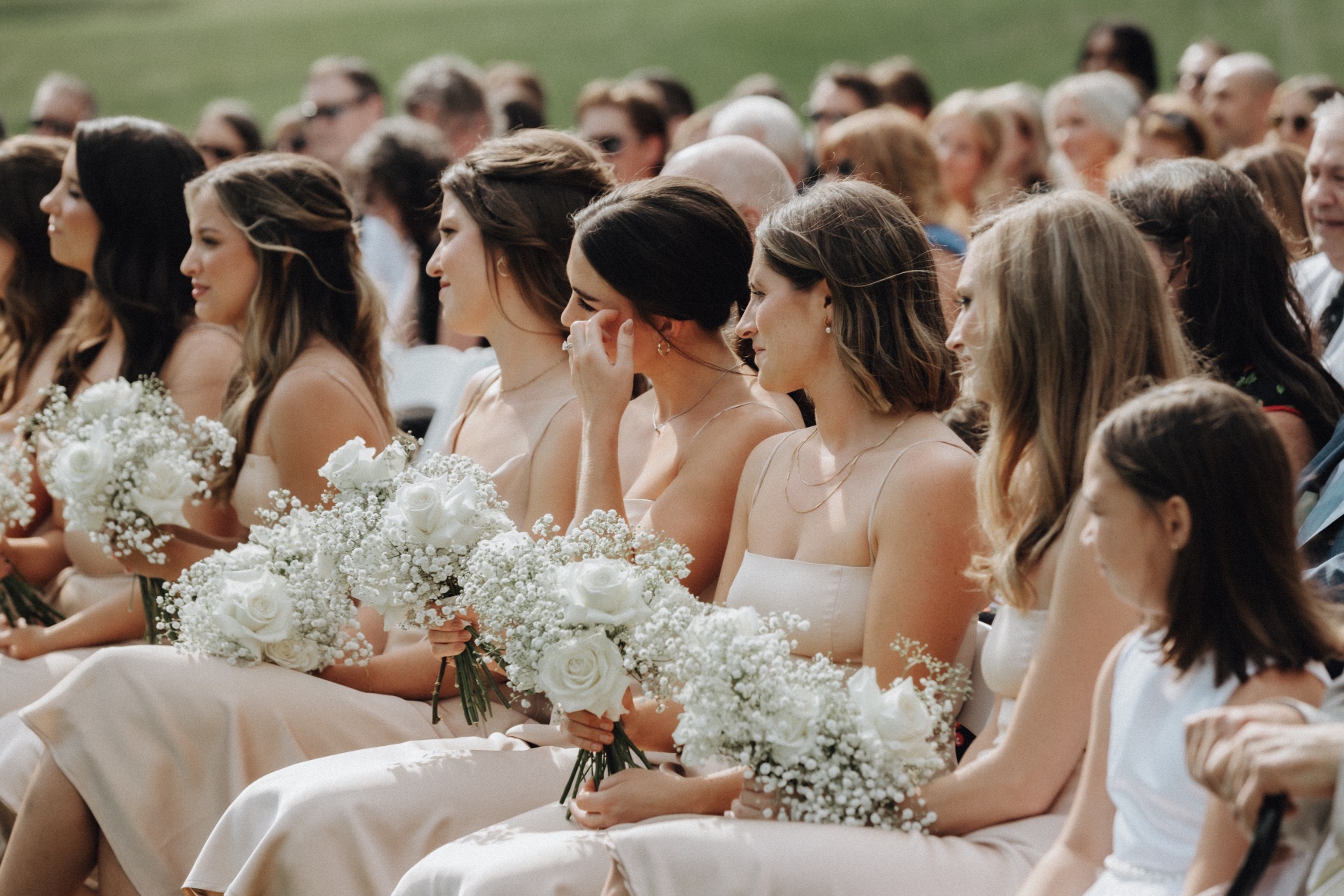 Bridesmaids A row of Tianna's bridesmaids sitting in their champagne gowns, holding onto their bouquets as they watch the ceremony.
