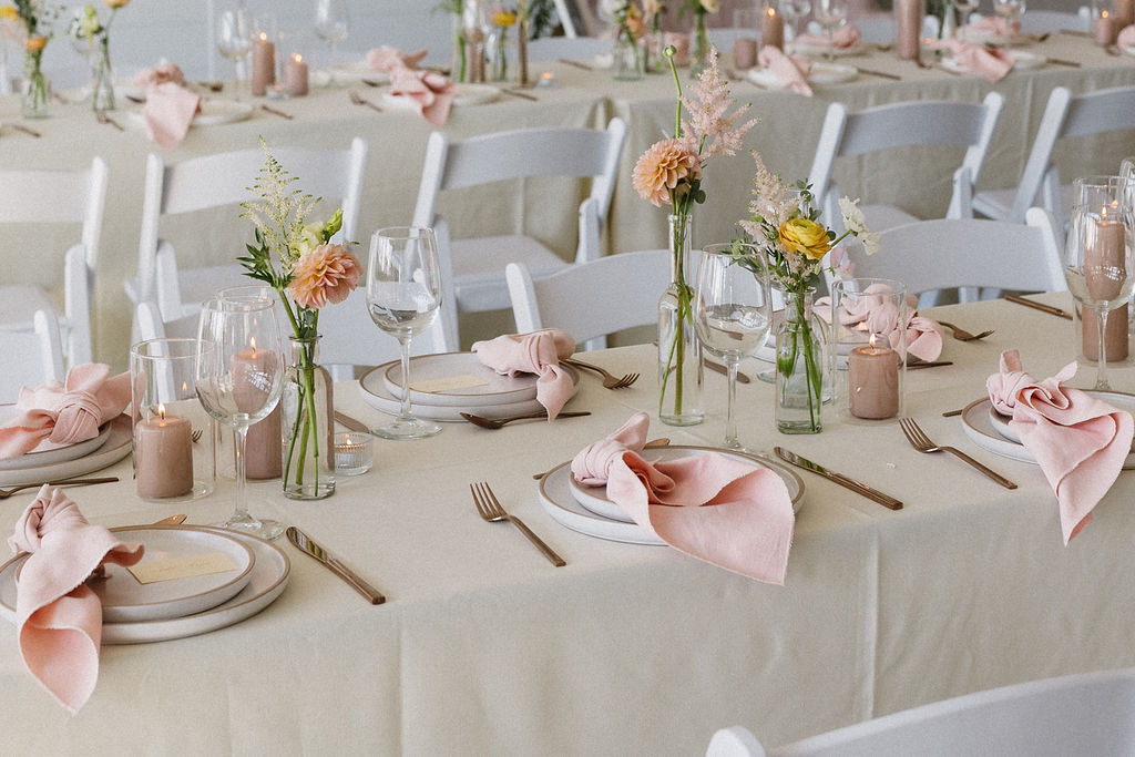 Pretty pink and peach bud vase arrangements adorning the tables at the reception.