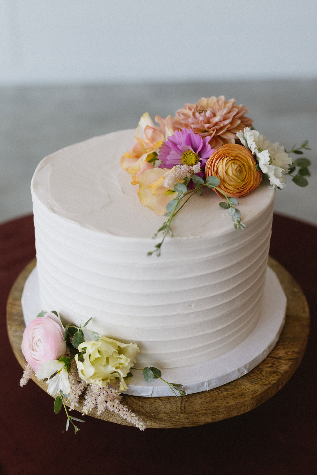 A detail shot of the adorable pink and peach blooms accenting the elegant wedding cake.