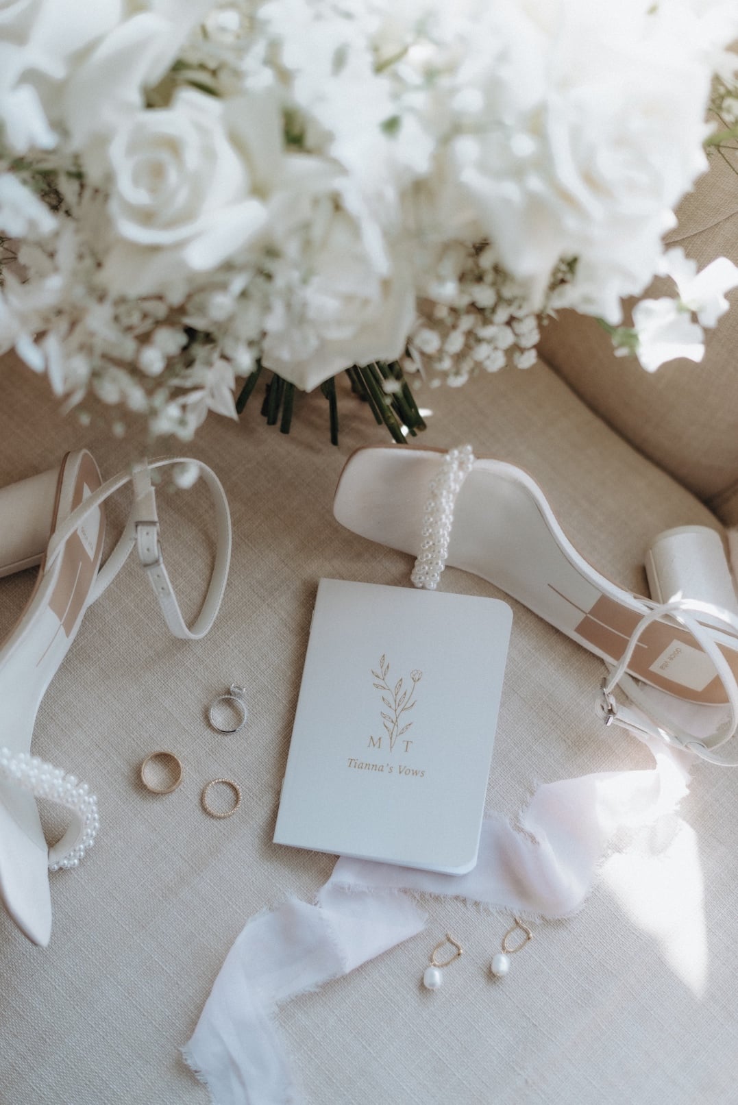 Flatlay A flat lay image showing Tianna's bouquet, strappy shoes, wedding rings and printed vows.