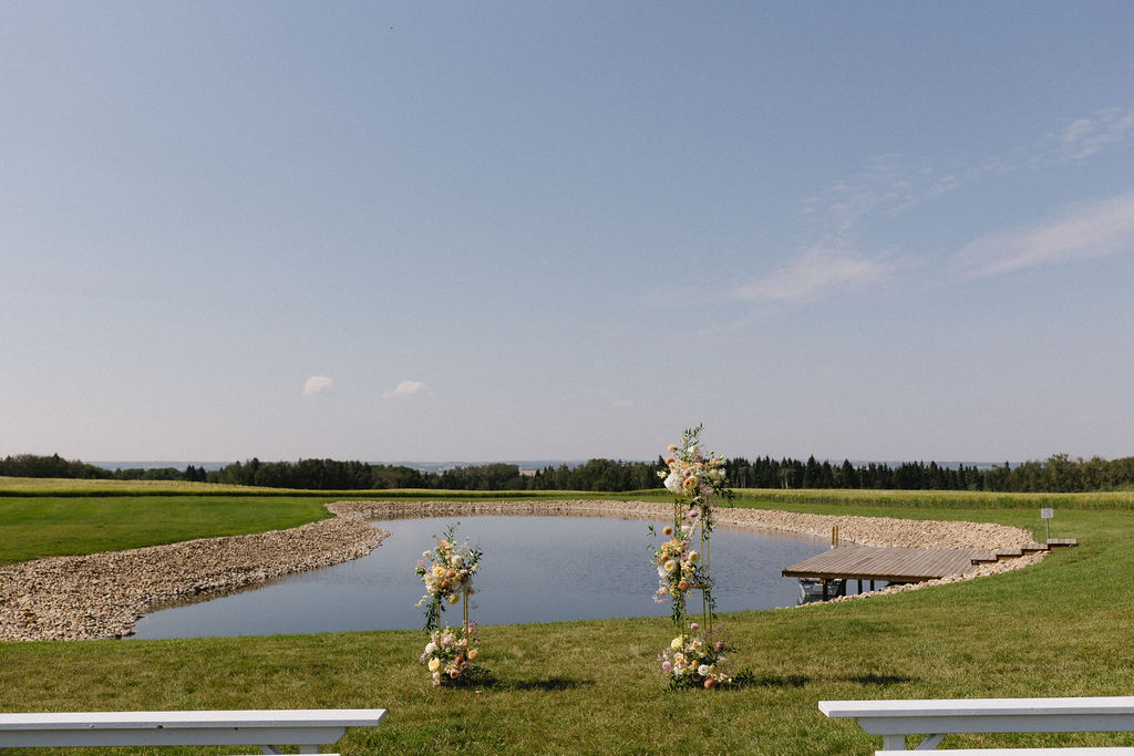 The pastel floral stands set up at the end of the aisle to frame the couple as they say their "I dos".