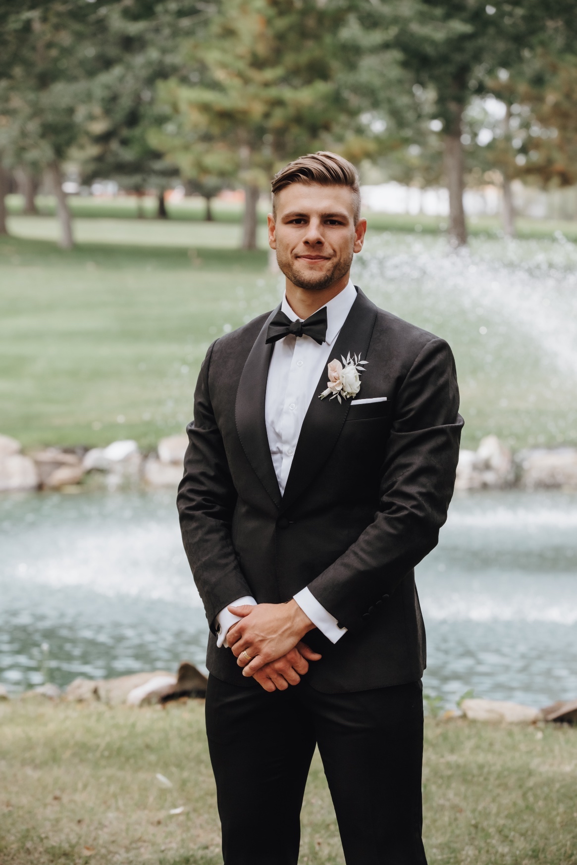 Groom Mitchell looking sharp in a tuxedo, with a "mini bouquet" styled boutonniere.