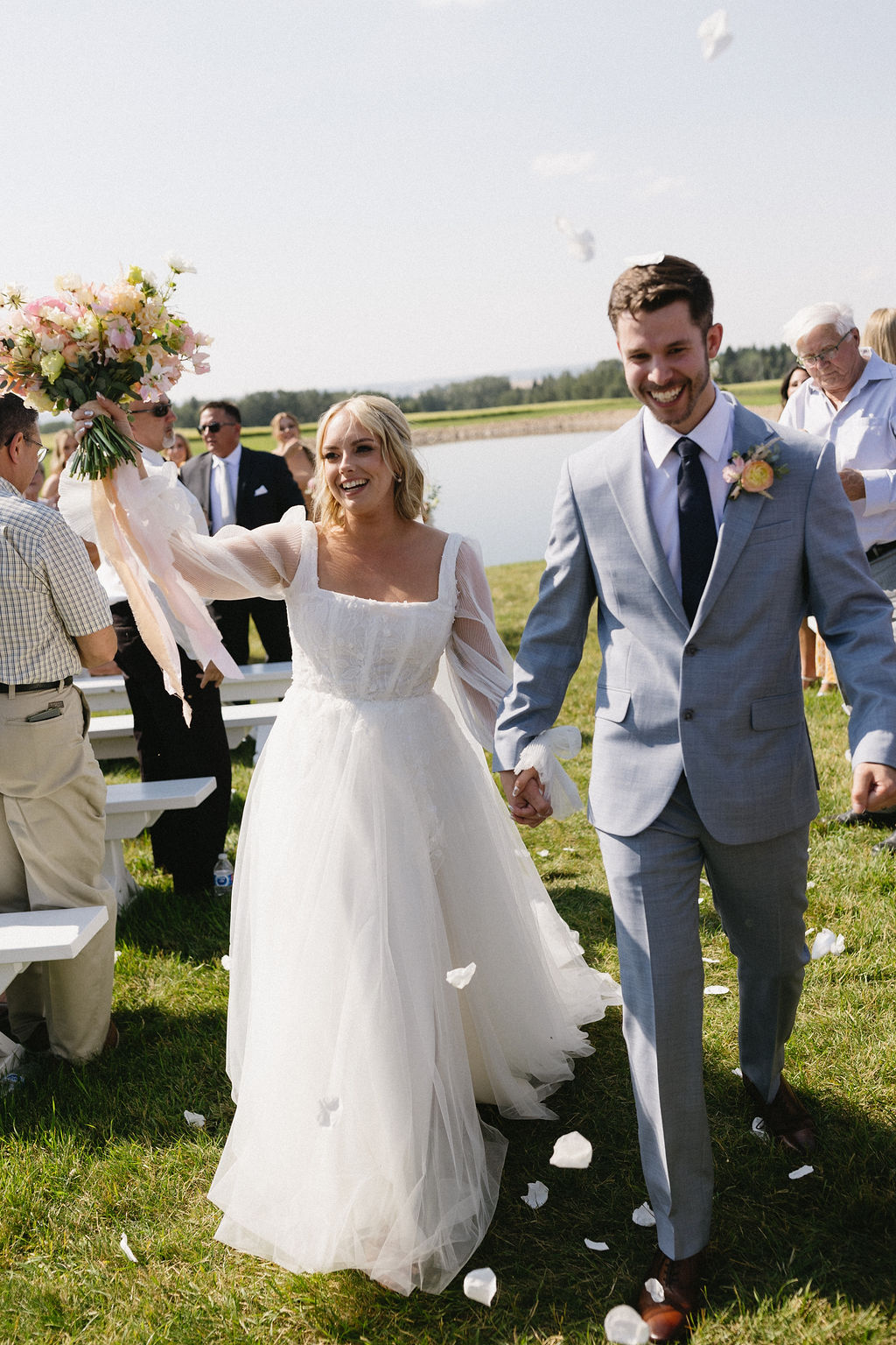 Elated McKinley and Eric celebrating as they walk down the aisle at the end of the wedding ceremony.
