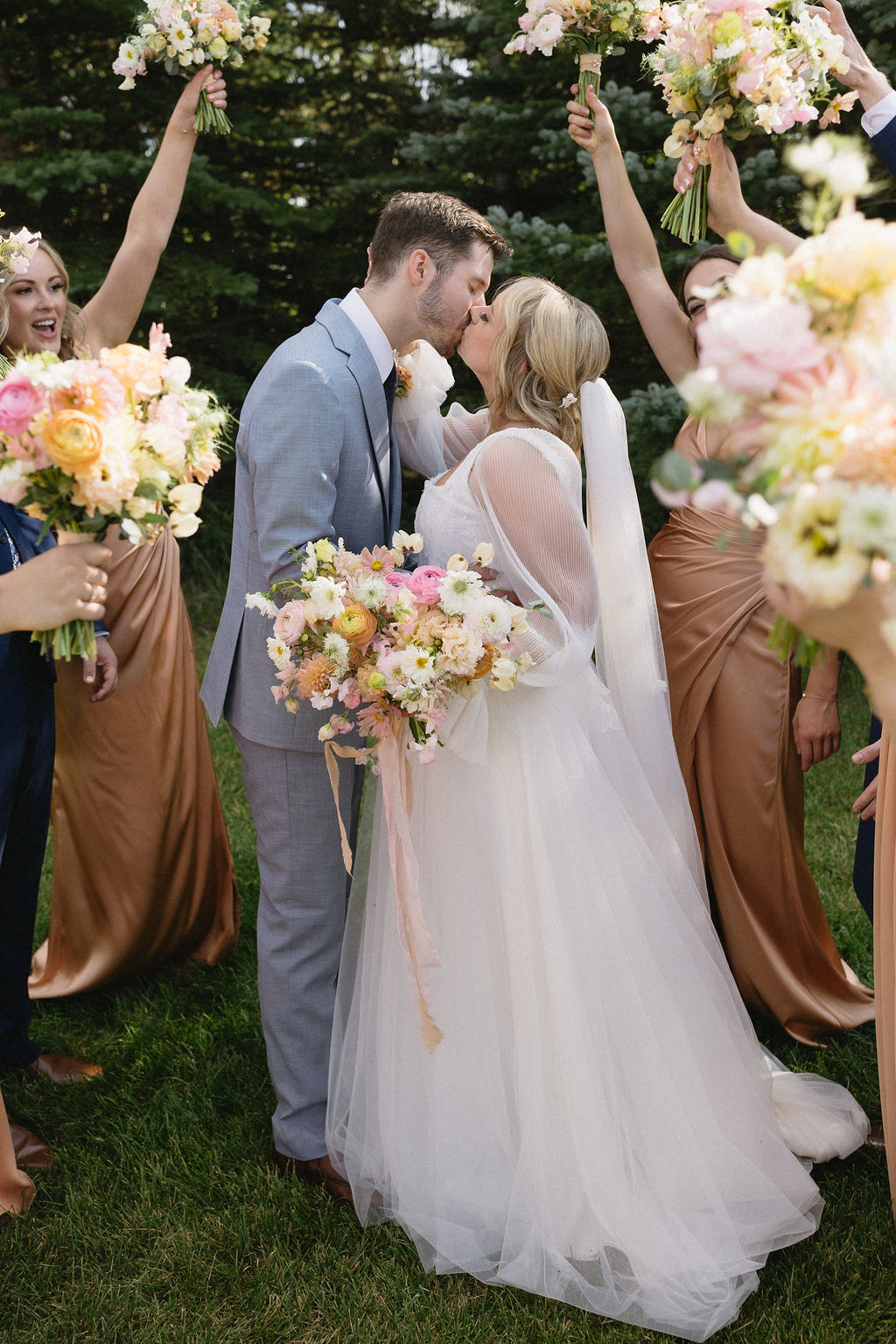 McKinley and Eric sharing a kiss, and their bridal party celebrating around them.