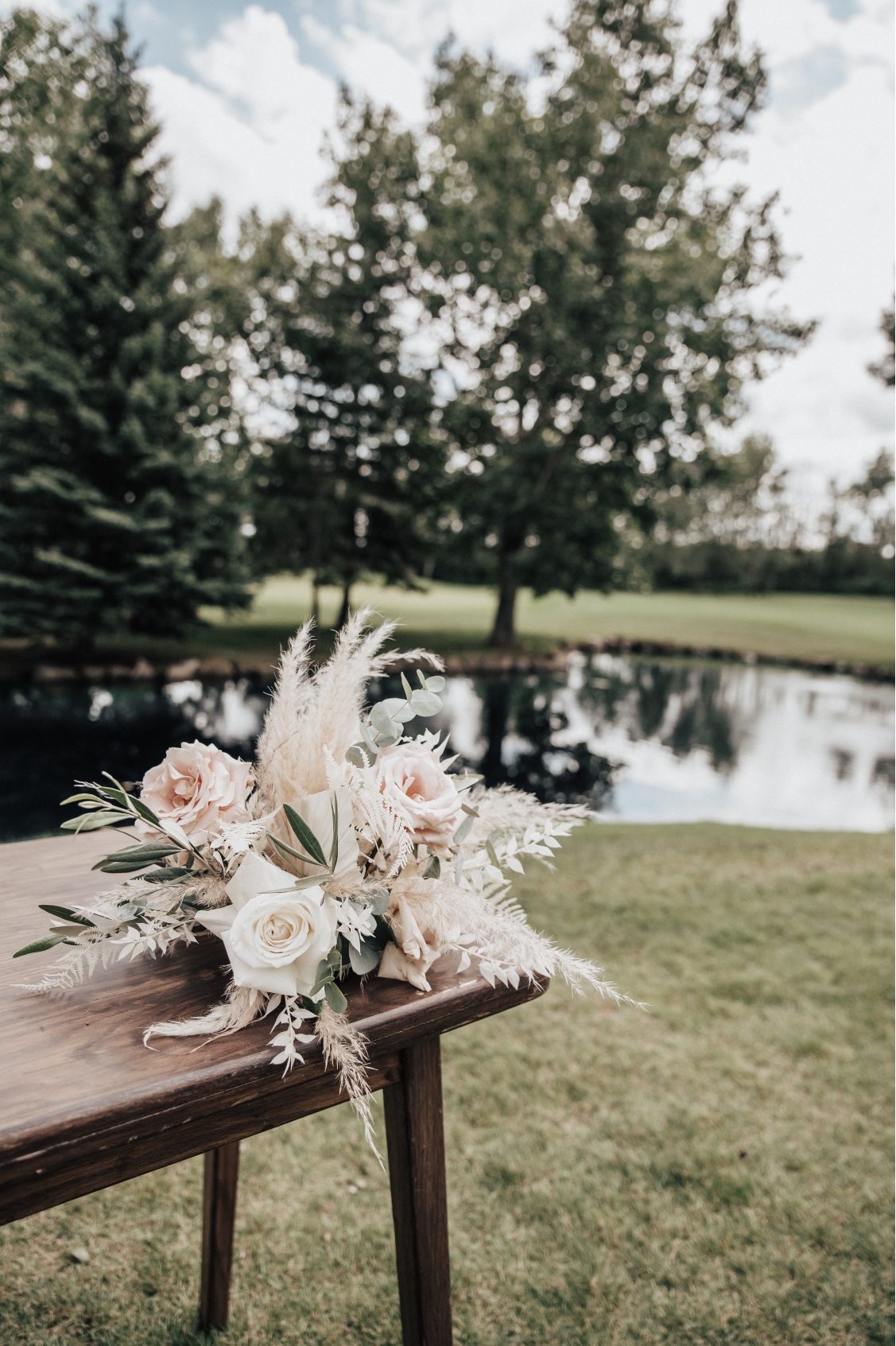 A beautiful arrangement of pampas grass, roses, eucalyptus and olive on the signing table.