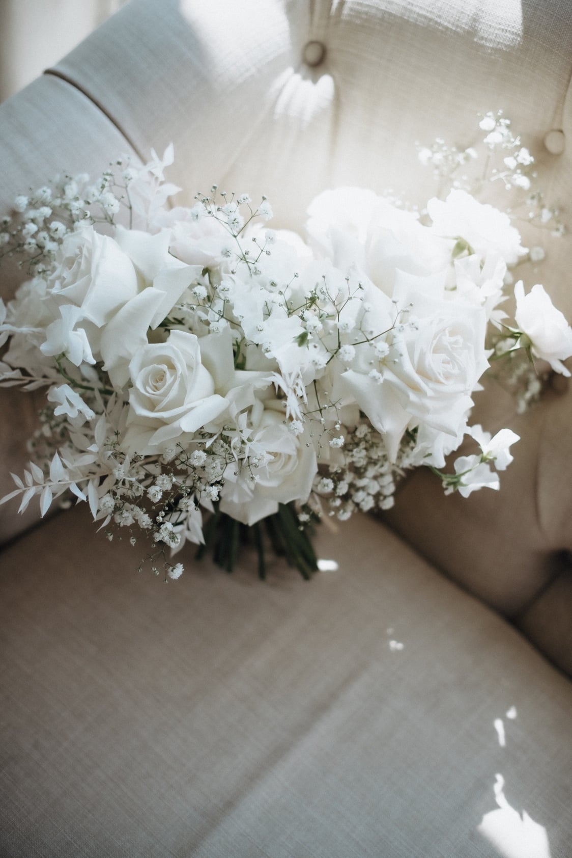White Bouquet Tianna's white and ivory bouquet of roses, lisianthus, ranunculus, sweet peas, baby's breath and bleached ruscus.